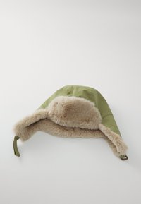 Chapeau rembourré vert avec doublure et bord en fausse fourrure. Présente une texture douce et une sangle ajustable d'un côté.