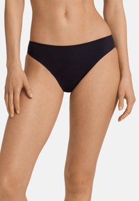Fondo di bikini nero con un design a vita bassa, texture liscia e taglio minimalista. Presenta bordi senza cuciture per comfort e un aspetto elegante.