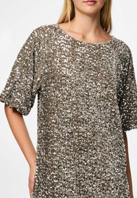 Krátký rukáv top pokrytý flitry v metalické taupe barvě, s kulatým výstřihem a texturovaným povrchem s reflexními stříbrnými akcenty po celém povrchu.