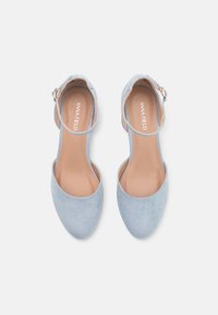 Light blue suede heels with a pointed toe, ankle strap, and adjustable buckle. Smooth texture, minimalistic design, and cushioned insole.