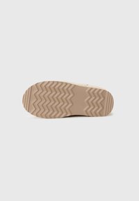Beige Sneaker-Sohle mit Zickzackmuster; strukturiertes Gummi-Material bietet Grip; abgerundete Form mit einem dezenten, flachen Profil.