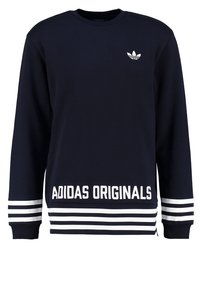 Sudadera azul marino con mangas largas, puños y bajo acanalados. Presenta el texto blanco 'ADIDAS ORIGINALS' y tres rayas blancas en las mangas.