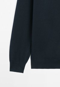 Granatowy sweter z długim rękawem, z prążkowanymi ściągaczami na mankietach i dolnym brzegu, na białym tle.