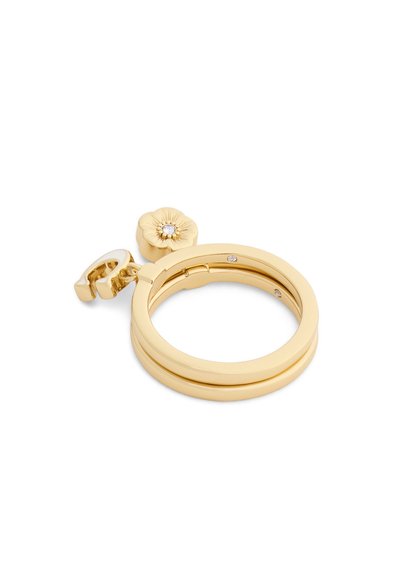 Boucle d'oreille à anneau doré ornée de petits cristaux intégrés, avec un pendentif fleur au cristal central et un pendentif lettre "C" attaché.