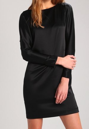 Robe en satin noir avec des manches longues, un col rond et une silhouette ajustée. Texture lisse et design minimaliste sans motifs.
