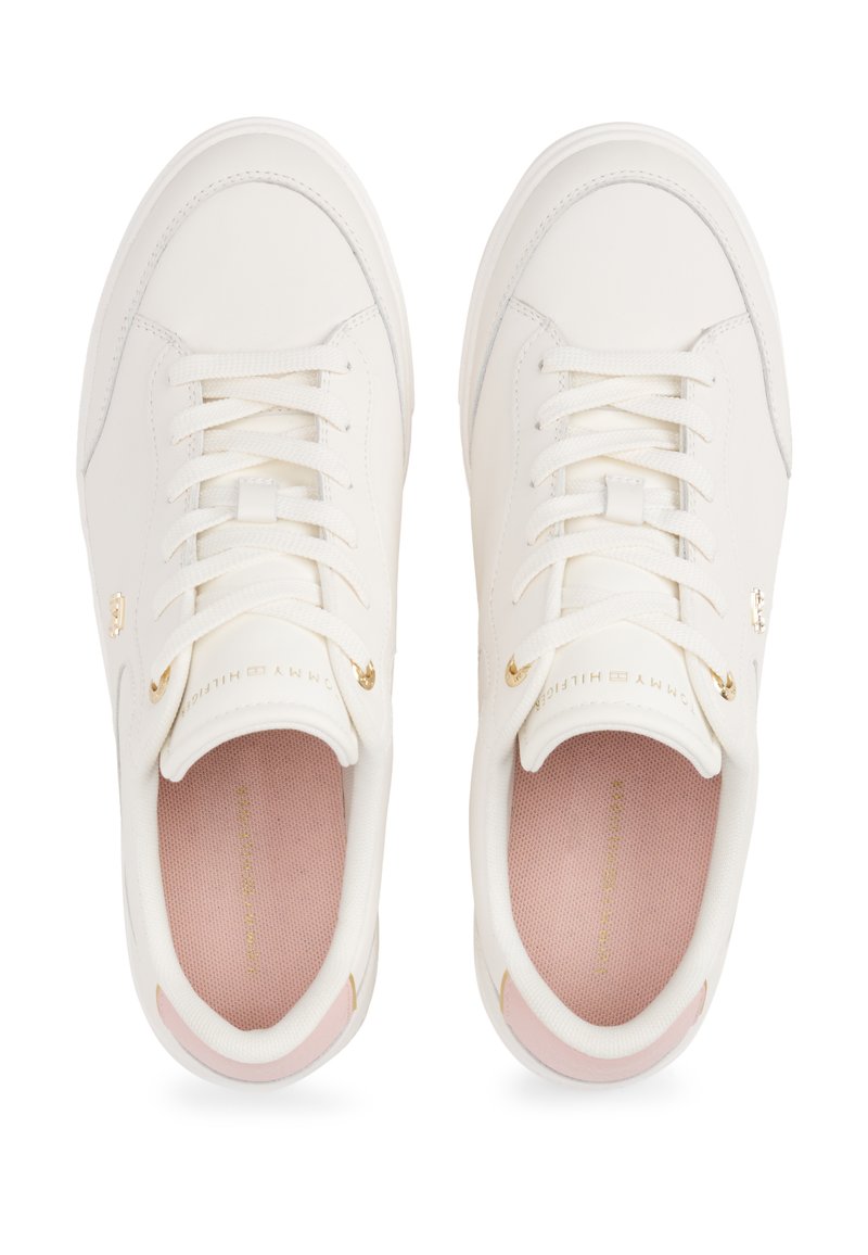 Baskets en cuir blanc avec une texture lisse, bout rond, lacets minimalistes, accents métalliques et une semelle intérieure rose avec un branding doré.