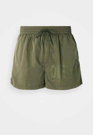 Olive green swim shorts made of lightweight fabric, featuring an elastic waistband with drawstring and printed logo detail on the front.