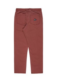Rode katoenen broek met een elastische tailleband, twee achterzakken en een klein logo-label boven de rechterzak. Platte voorkant en taps toelopende benen.