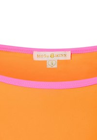 Oranje top met een ronde hals, voorzien van een roze rand en een label met "MODA MINX" in gouden letters op een witte achtergrond.