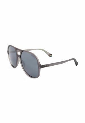Occhiali da sole Polaroid grigi stile aviatore con lenti scure e un piccolo dettaglio arcobaleno sulla punta delle aste su sfondo bianco.