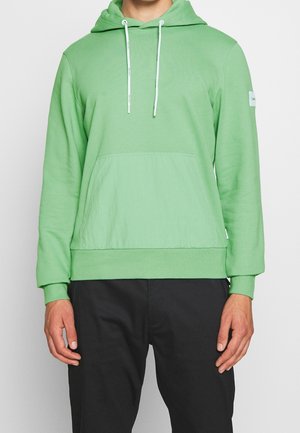 Hoodie vert en matériau doux, comportant une poche kangourou, une capuche avec cordon de serrage ajustable, et des poignets et un ourlet côtelés.