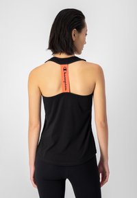 Top atlético negro sin mangas con un diseño de dobladillo curvado y un destacado logo rojo en la parte posterior. Tela suave y transpirable.