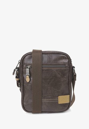 Bolso cruzado de cuero marrón con forma cuadrada, que cuenta con un bolsillo con cremallera, correa de tela, detalles de costura y una etiqueta con logo.