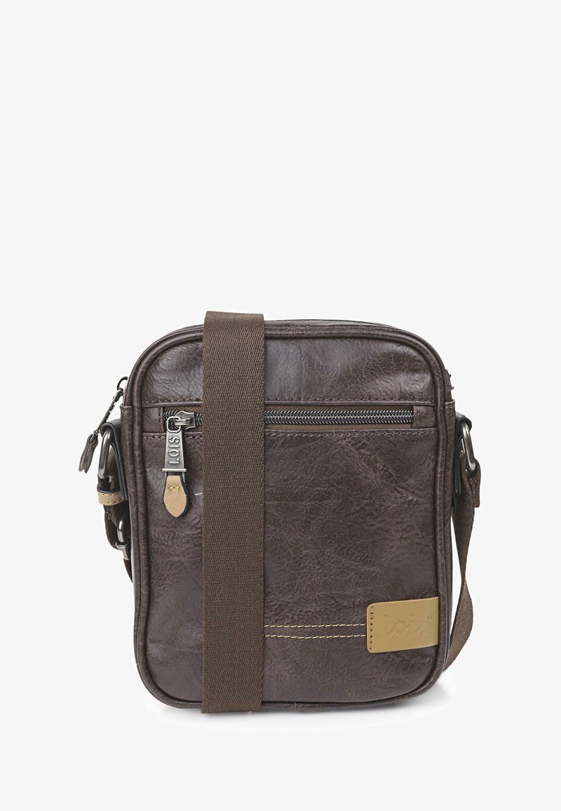 Bolso cruzado de cuero marrón con forma cuadrada, que cuenta con un bolsillo con cremallera, correa de tela, detalles de costura y una etiqueta con logo.