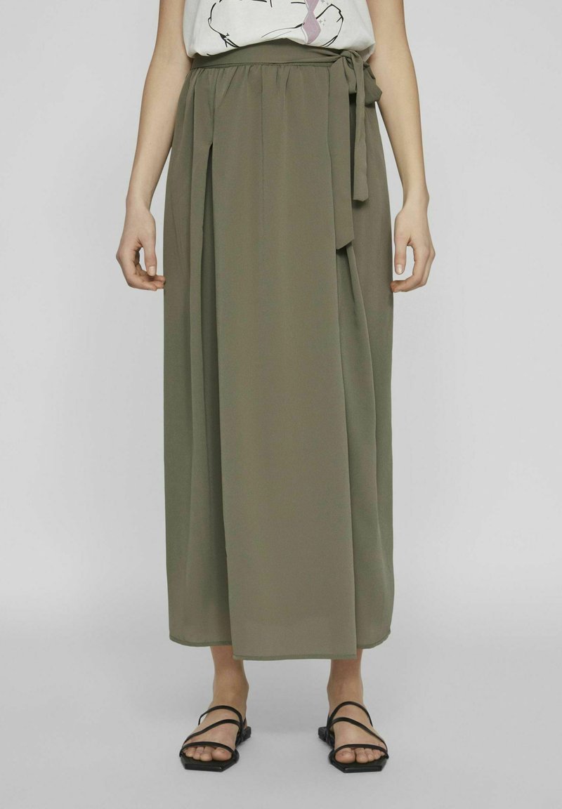 Olijfgroene, geplisseerde maxi rok met een hoge taille en een strikdetail. Lichtgewicht stof met een vloeiende uitstraling en een enkellange zoom.
