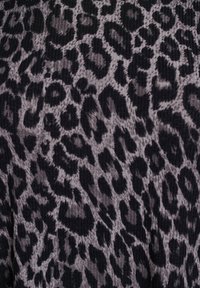 Svart och grå leopardmönstrad tyg med ribbad textur. Mönstret innehåller stora, oregelbundna fläckar och subtila detaljer.