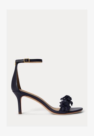 Tengerészkék magassarkú szandál bokapánttal és csattal, nyitott orral, valamint két díszítő virágmotívummal az elülső pánton.