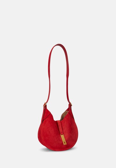 Rdeča semiš torbica za čez ramo s ukrivljeno silhueto, z zlatimi kovinskimi dodatki in dolgim trakom. Ponaša se z mehko teksturo in minimalističnim dizajnom.