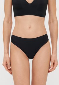 Μαύρο μπικίνι κάτω με λείο, ελαστικό ύφασμα. Διαθέτει μεσαίο ζωνάκι και μέτρια κάλυψη. Απλός και χωρίς ραφές σχεδιασμός.