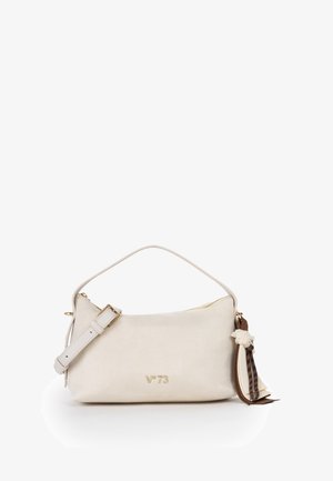 Handtas in roomkleur met korte handgreep, verstelbare band, gouden rits, "V°73" logo en decoratieve stoffen tassel op witte achtergrond.