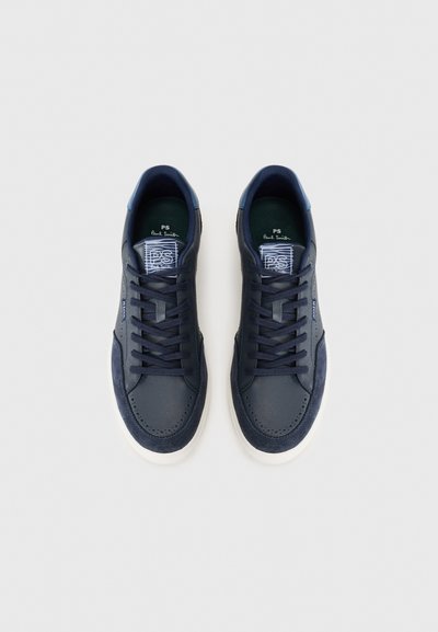 Marinblå lädersneakers med mockadetaljer, rund tå och vit gummisula. Har mörka snören och en texturerad tunga med logotyp.