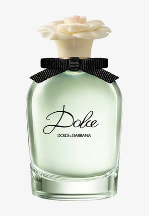 Flacon de parfum transparent avec un liquide vert pâle, un nœud papillon noir et un bouchon crème en forme de fleur, étiqueté Dolce par Dolce & Gabbana.