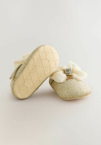 Goldene Glitzer-Ballettschuhe mit weißen Satin-Schleifen, einer sanft strukturierten Oberseite und einer strukturierten Gummisohle mit einem Diamantmuster.