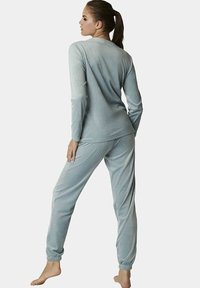 Lichtblauwe velours pyjama set met lange mouwen en elastische boorden op de broek. Soepele textuur, comfortabele pasvorm en eenvoudig ontwerp.