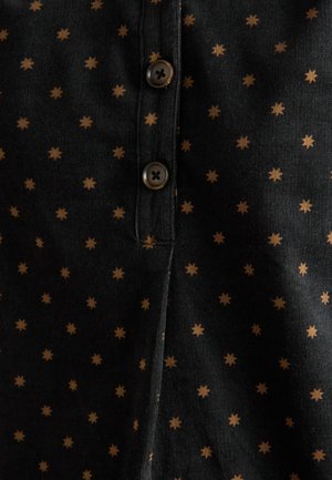 Melnā auduma krekls ar mazu brūnu zvaigžņu rakstu, kas aprīkots ar pogu aizdari un teksturētu virsmu. Redzamas divas brūnas pogas.