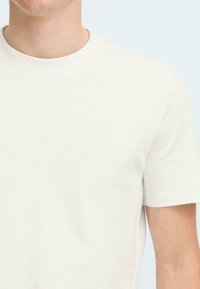 Crew-neck t-shirt in lightweight white cotton. Short sleeves and a smooth, even texture. No visible patterns or hardware details.