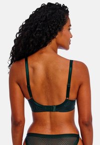 Soutien-gorge vert avec un motif géométrique, des bretelles réglables et une fermeture à crochet et œillet. Texture lisse avec un design en contour.