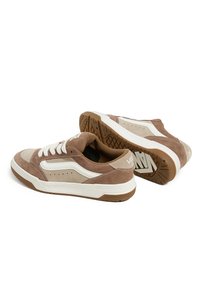 Brown suede sneakers with white accents, featuring perforations for breathability, lace-up design, and textured rubber outsole.