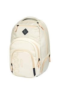 Zaino in tela crema con accenti neri, numerosi scomparti con zip e un design testurizzato; presenta un evidente motivo di cucitura.