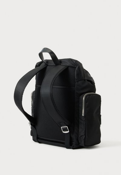 Sac à dos noir avec bretelles rembourrées, panneau arrière en maille, poignée supérieure et poche latérale zippée, présenté de dos et de côté.