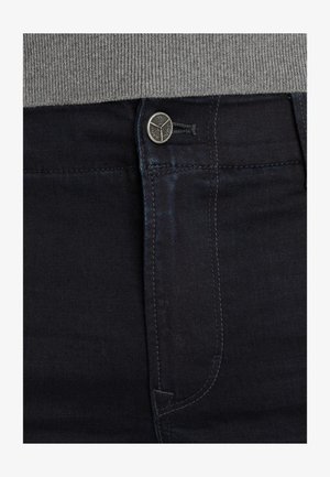 Mørk denim jeans med en glat tekstur, der har en metal knaplukning, kontrastsyninger og en slim-fit design nær taljen.