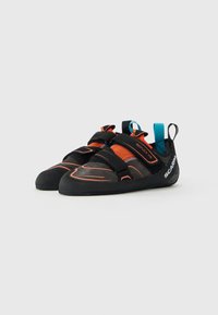 Et par svarte og oransje klatresko med borrelåsstropper og blå dragbånd, modell "Reflex VS" fra Scarpa, på hvit bakgrunn.
