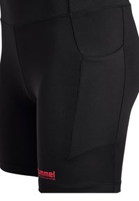 Svarta idrottshorts med ett slätt, elastiskt tyg. Har en sidoficka och en liten röd logotyp på benet. Designade för prestation.