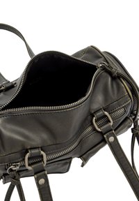 Czarna skórzana torebka z suwakami, regulowanymi paskami i miękką fakturą. Wnętrze jest przestronne, wyłożone ciemną podszewką, bez widocznych przegródek.