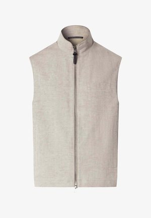 Chaleco beige sin mangas con cuello alto y cierre de cremallera plateada de largo completo, con discretos bolsillos laterales y un detalle minimalista en el pecho.