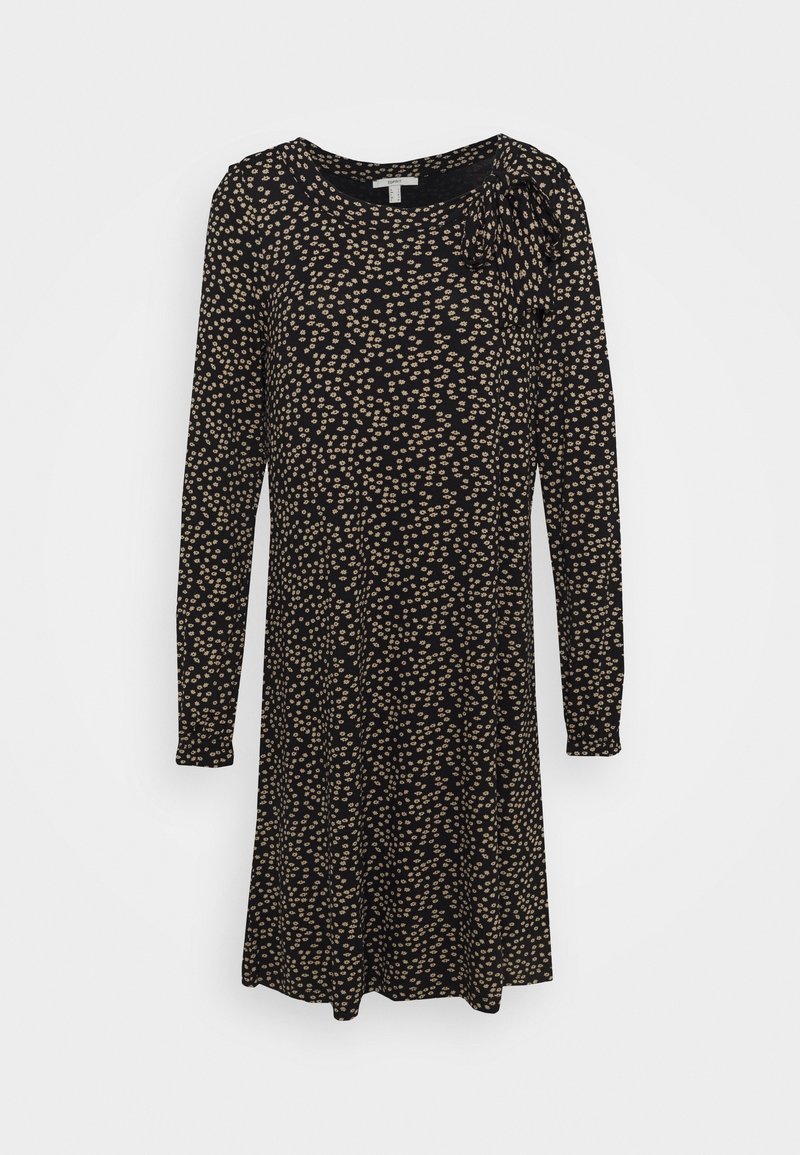 Robe noire à manches longues avec un petit imprimé floral beige et un nœud noué sur l'épaule gauche, longueur au genou, coupe droite.