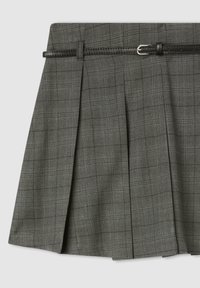 Gonna a quadri grigi con pieghe, una cintura nera con una fibbia metallica e un tessuto testurizzato. Misura fino al ginocchio per un tocco di stile.