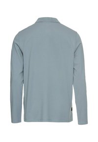 Koszula polo z długim rękawem w jasnoniebieskim kolorze. Posiada ribbowany kołnierzyk i mankiety, oraz prosty dół. Brak widocznych wzorów lub grafik.