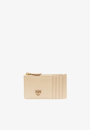 Portafoglio in pelle beige con chiusura a zip, dotato di quattro slot per carte e un accento con logo dorato sul davanti. Texture liscia, design minimalista.