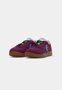 Purple sneakers with a textured fabric upper, blue accents, and black laces. Features a cushioned sole and a gum rubber outsole.