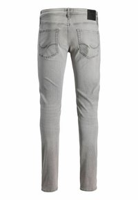 Ανοιχτόγρινο στενό τζιν τζιν με δύο πίσω τσέπες και μια μαύρη ετικέτα μάρκας στη ζώνη, εμφανιζόμενο από πίσω.