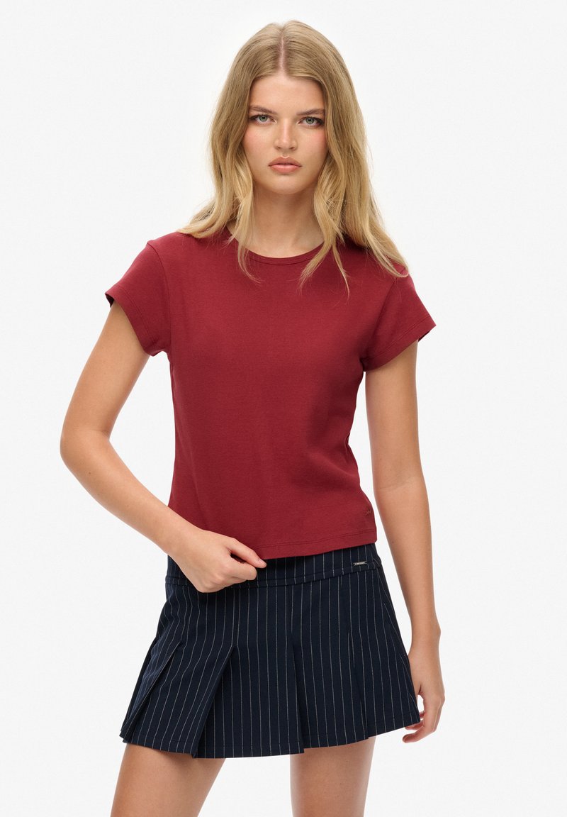Bordeaux bomulds T-shirt med runde hals og korte ærmer, paired med en marineblå stribet plisseret nederdel. Enkel design og tætsiddende snit.