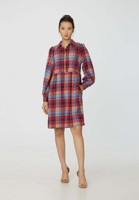 Robe à carreaux rouge, bleu et orange avec un col, fermeture éclair à l'avant, manches bouffantes longues et taille cintrée. Tissu lisse et longueur genou.