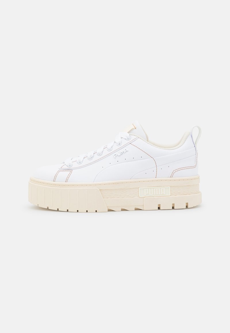 Sneakers bianchi a bassa altezza con una suola piatta in crema testurizzata, caratterizzati da una parte superiore liscia, dettagli di cuciture sottili e un accento del logo.