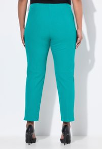 Tyrkysové kalhoty z hladkého, elastického materiálu, s přiléhavým střihem, délky po kotníky a pohodlným elastickým pasem.