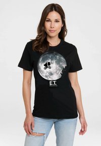 Black T-shirt featuring a large graphic of a full moon with a silhouette of a boy on a bicycle and an alien, labeled "E.T." at the bottom.
